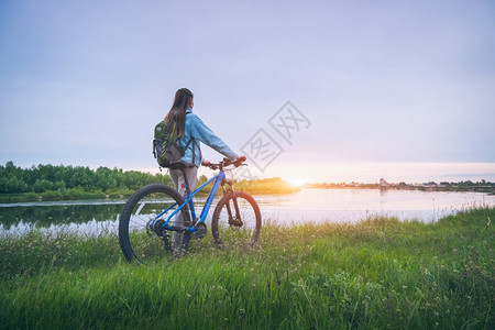在河边骑自行车的妇女图片