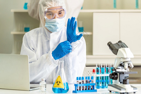 亚洲科学家在研究并试验冠状共19疫苗之前先在科学实验室戴上个人防护设备手套医学科技和保健概念图片