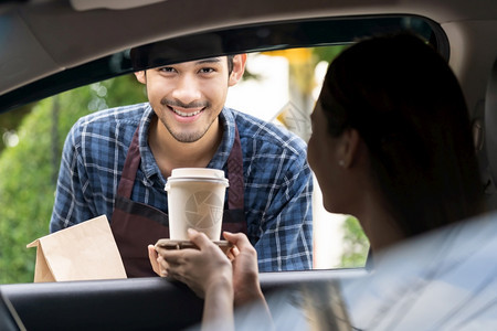 服务人员向汽车司机提供咖啡图片