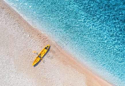 在夏季阳光明媚的下海滨有透明的蓝水在克罗地亚旅行最亮的船景日落时有皮艇的陆地景观旅行背景图片