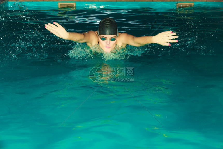 游泳女运动员在池中表演蝴蝶风格的划线活跃人类游泳运动员在呼吸水上运动联合会游泳女运动员在池中蝴蝶风格的划线图片