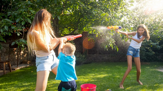 家庭在夏季户外玩耍和乐快的儿童在夏季玩水和花园房子玩耍图片