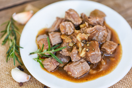 白切牛肉配有酱汁和香料的大蒜牛肉切和白盘上煮饭的牛肉背景