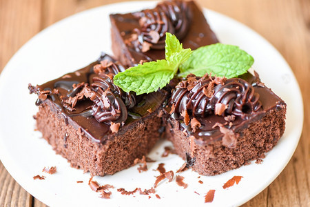 餐桌上的蛋糕巧克力甜点白盘上的蛋糕切片巧克力和薄荷叶图片