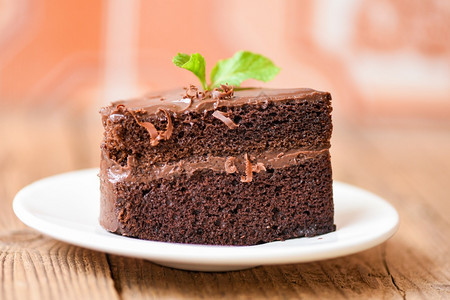 餐桌上的蛋糕巧克力甜点白盘上的蛋糕切片巧克力和薄荷叶图片