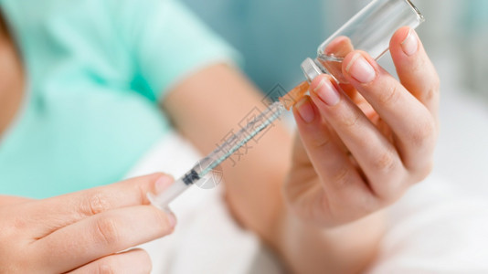 糖尿病妇女躺在床上用胰岛素填充注射器图片