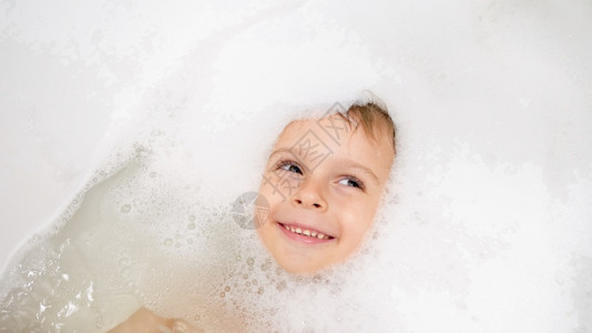 男孩被浸在肥皂泡沫游泳图片
