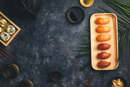 Nigiri寿司套餐配有鲑鱼和金竹盘上配有筷子大豆鱼黄瓜姜汁和深底茶美味的日本传统食物顶景平地复制空间图片