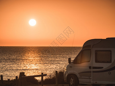 西班牙地中海岸日出时露营娱乐车在自然海滩露营度假和乘汽车回家日出时露营车在海滩上图片