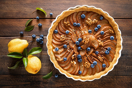 感恩节梨饼派或蛋糕配有新鲜梨蓝莓肉桂和胡桃图片