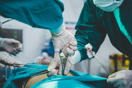 外科医生医院的外科生小组进行侵入外科手术室配备心血管紧急外科中心的电动设备背景