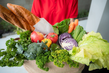 提供公司工人手持杂货袋食品订单超市服务接受在家送货的妇女食品箱新鲜有机蔬菜供应图片