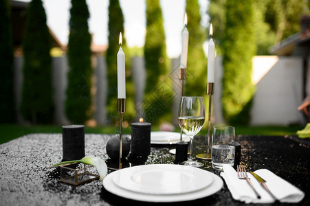 豪华银器户外餐具优雅的装饰夏季草原的浪漫庆祝黑色的桌布眼镜蜡烛和板图片