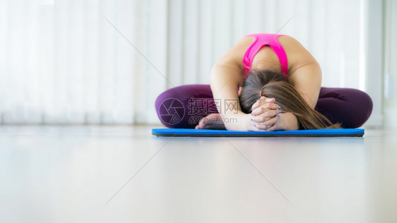 女青年在室内健身房的垫子上做瑜伽姿势有复制空间健康生活方式和概念图片
