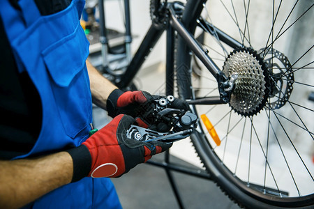 机动车修理间男子设置速度开关机械师在制服上修补自行车周期问题专业自行车修理服务图片