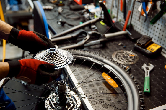 修理车间的自行人安装恒星磁带修理周期有制服问题的机械师专业自行车修理服务车间的自行修理人安装磁带图片