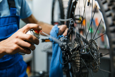 修理车间的自行人清洗明星磁带特机修理周期有制服问题的机械师专业自行车修理服务车间的自行人清洗磁带图片