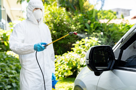 专门清洁人员穿戴个防护设备PPE用化学酒精喷雾进行洗车消毒和共冠病19次图片