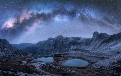 高山湖泊紫色天空有乳状的拱形和恒星在水中反射高岩石多洛米特人意大利空间和银河系图片