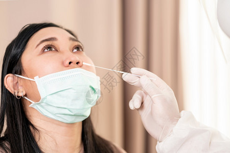 个人防护设备服检验科罗纳coronaviruscovid19的医务人员在院通过鼻腔擦拭对亚裔妇女进行检测新冠19检验保健概念图片