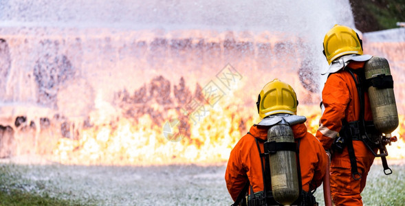 使用化学泡沫灭火器来对付油轮卡车事故的火焰全景消防员安全事故和公共服务概念图片