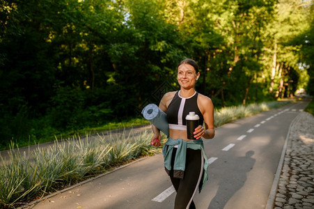 女跑者在阳光明媚的白天参加体育活动健康的生方式户外运动员公园培训有垫子和水的妇女图片