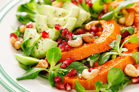 新鲜蔬菜沙拉配有绵羊生菜烤花瓜或南鳄梨石榴腰果和杏仁健康素食品概念图片
