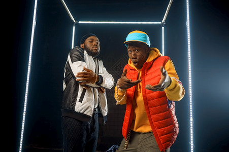 两个时髦的说唱者在发光立方体中出现工作室背景暗Hiphop表演者断层舞两个时髦的说唱者在发光立方体中出现图片