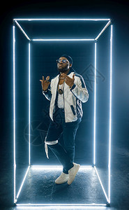 太阳镜中时尚的说唱歌家在光亮的立方体中出现黑暗背景中出现Hiphop表演者饶舌歌手散舞表演娱乐生活方式中出现太阳镜的Rapper图片