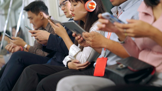 在公共地下火车上使用移动电话的年轻人城市生活方式和亚洲通勤概念图片