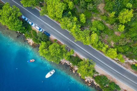 在美丽的绿林和春季日落时的海岸美丽绿林和海岸空中道路景色公船只蓝水夏季树木上有汽车的多彩景观克罗地亚高速公路的顶端景色图片