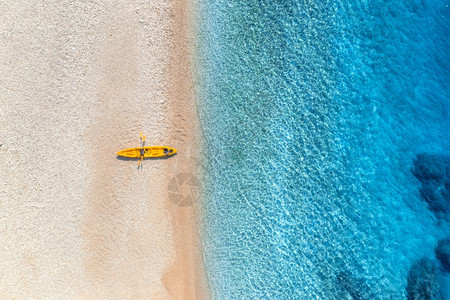 在夏季阳光明媚的下海滨有透明的蓝水在克罗地亚旅行最亮的船景日落时有皮艇的陆地景观旅行背景图片