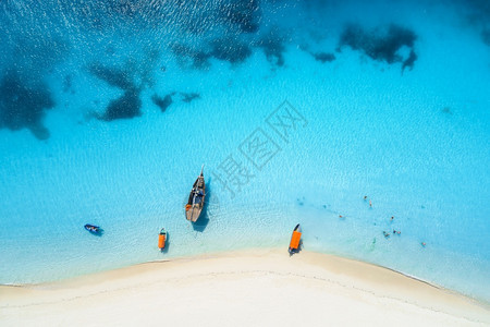 热带海岸的游艇和渔船空中景象夏季日落时有白沙滩图片