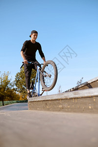 滑板男孩超级自行车运动危险的自行车运动冒险街头骑马在夏季公园骑自行车背景