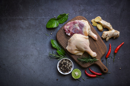 生鸭腿配有草药香料准备在木制剪板上做饭新鲜鸭肉作为食物最高视图背景图片
