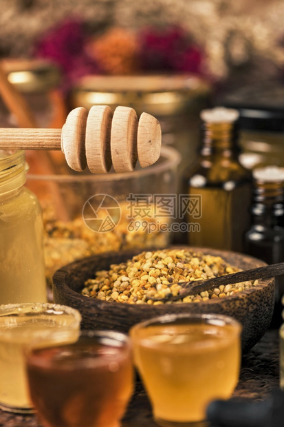 不同种类的蜂蜜花粉蛋白和桌上的木制蜂蜜薄饼和制品图片