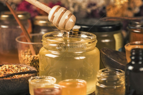 各种蜂蜜花粉和木制蜂蜜瓶图片