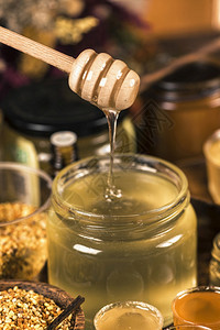 各种蜂蜜花粉和木制蜂蜜瓶图片