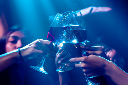社交聚会和夜生活娱乐概念一群人在夜舞俱乐部的聚会上为饮料敬酒背景