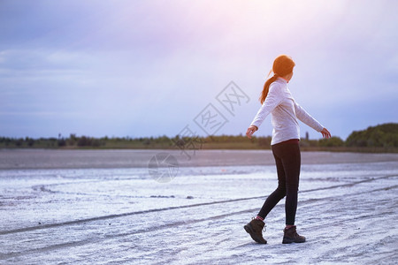 女孩沿着咸口河的海岸行走图片