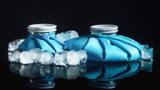 冰栗子冷治疗用于的可重复使用蓝冰袋以黑色反射背景隔离黑色背景上的冷治疗袋背景