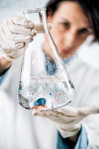 微塑料实验室分析科学家观察有水样的瓶子中微塑料或小粒图片