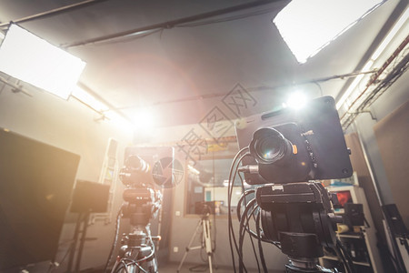 电视广播演室聚光灯和设备三脚架上的电影摄机图片