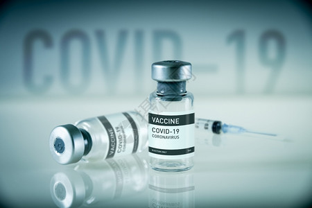 蓝实验室的新冠19疫苗瓶和注射器蓝背景的新冠19疫苗瓶和注射器图片