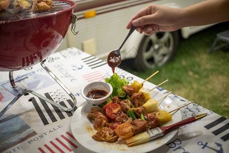 朋友做烧烤BBQ在大自然的热火上烧烤晚的宴背景图片