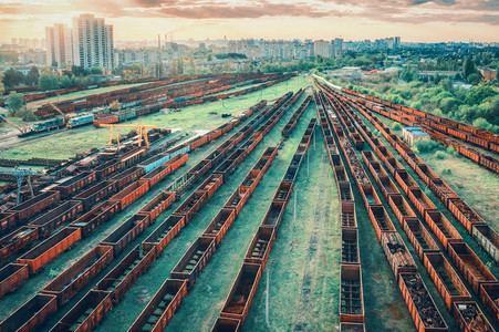 日落时客运列车的空中景象火车站铁路上的拖车重工业仓库中火车的工业景观绿树城市天空云层顶风景图片