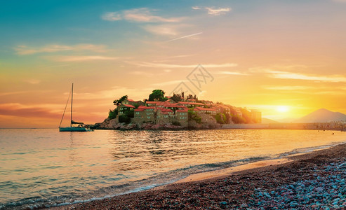 SvetiStefan城堡日落时在海边的一个岛上图片