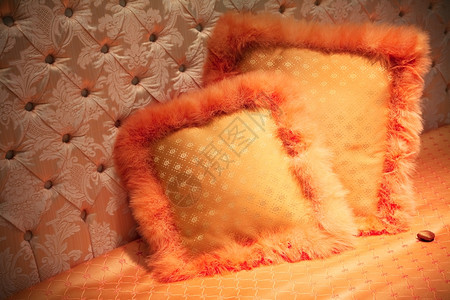 床上有毛绒的橙色枕头图片