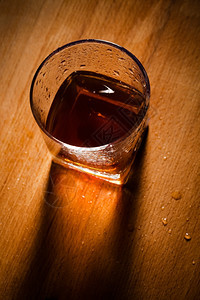 木制桌上的威士忌杯子图片