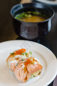 大米水稻烤鲑鱼卷寿司上面顶着虾蛋白菜上边配有大米汤鲑鱼卷寿司背景